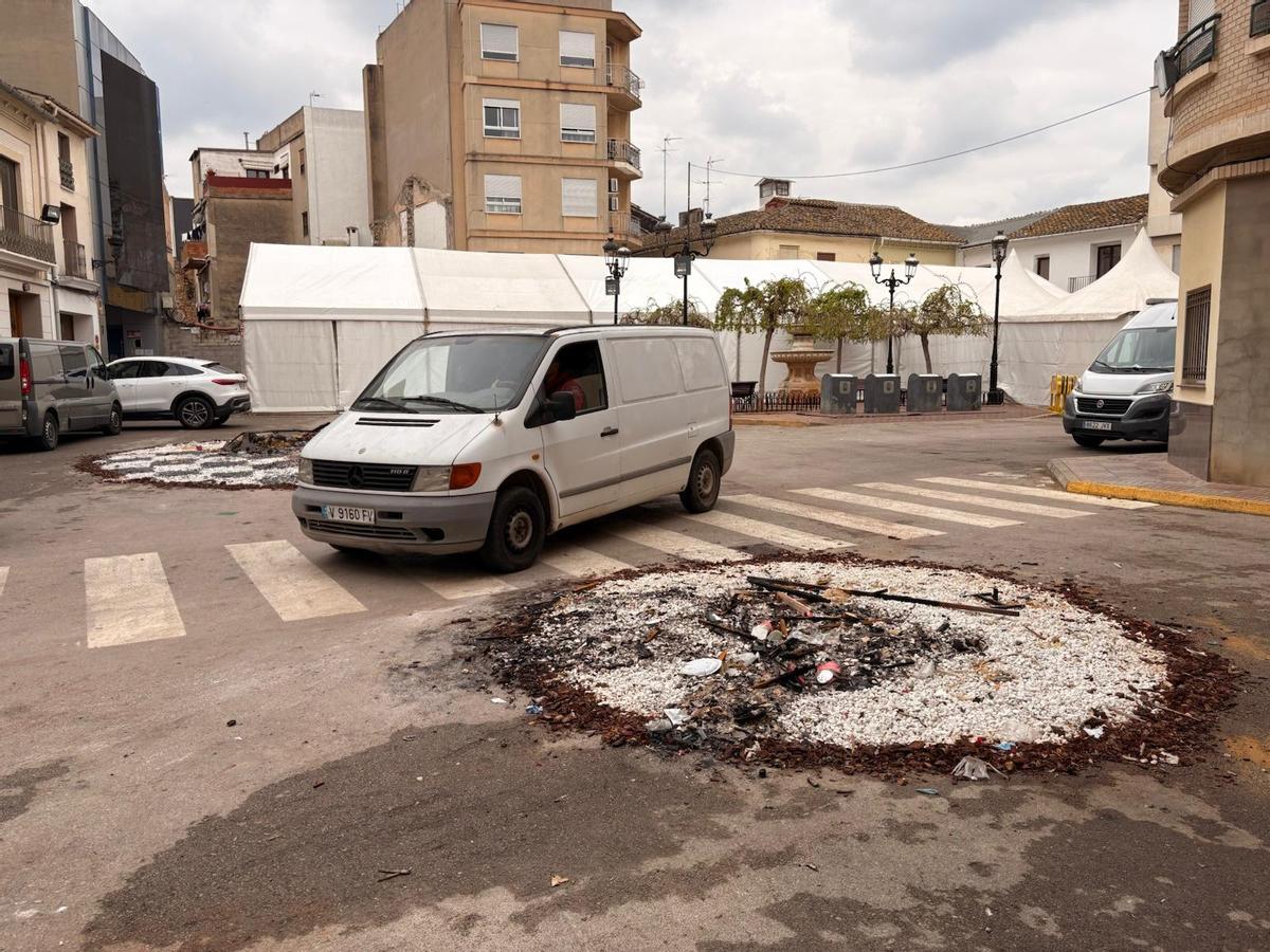 Restos de cenizas de la falla Mitja Capa y, al fondo, la carpa, en una imagen de este sábado.