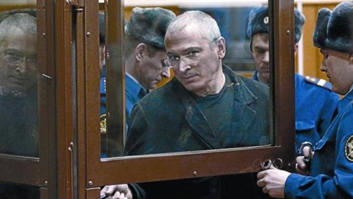 Mijail Jodorkovski es escoltado en sala del tribunal moscovita, ayer, donde debía seguir la lectura de la sentencia sobre su caso.
