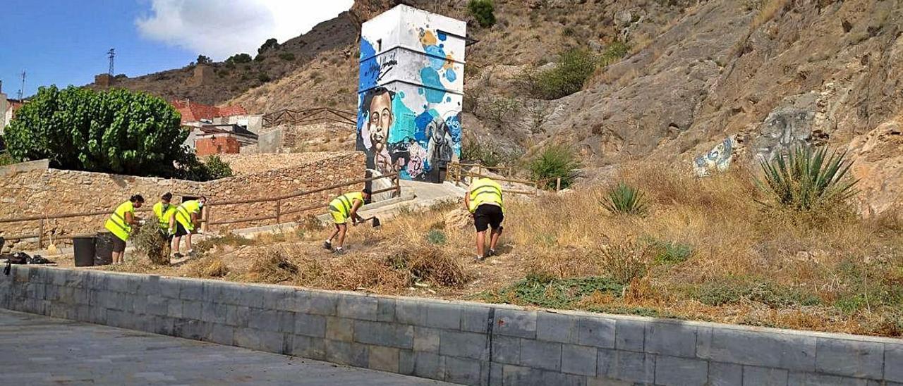 Un grupo de operarios lleva a cabo, ayer, la retirada de maleza y vegetación seca en la ladera del monte, cerca del rincón hernandiano.