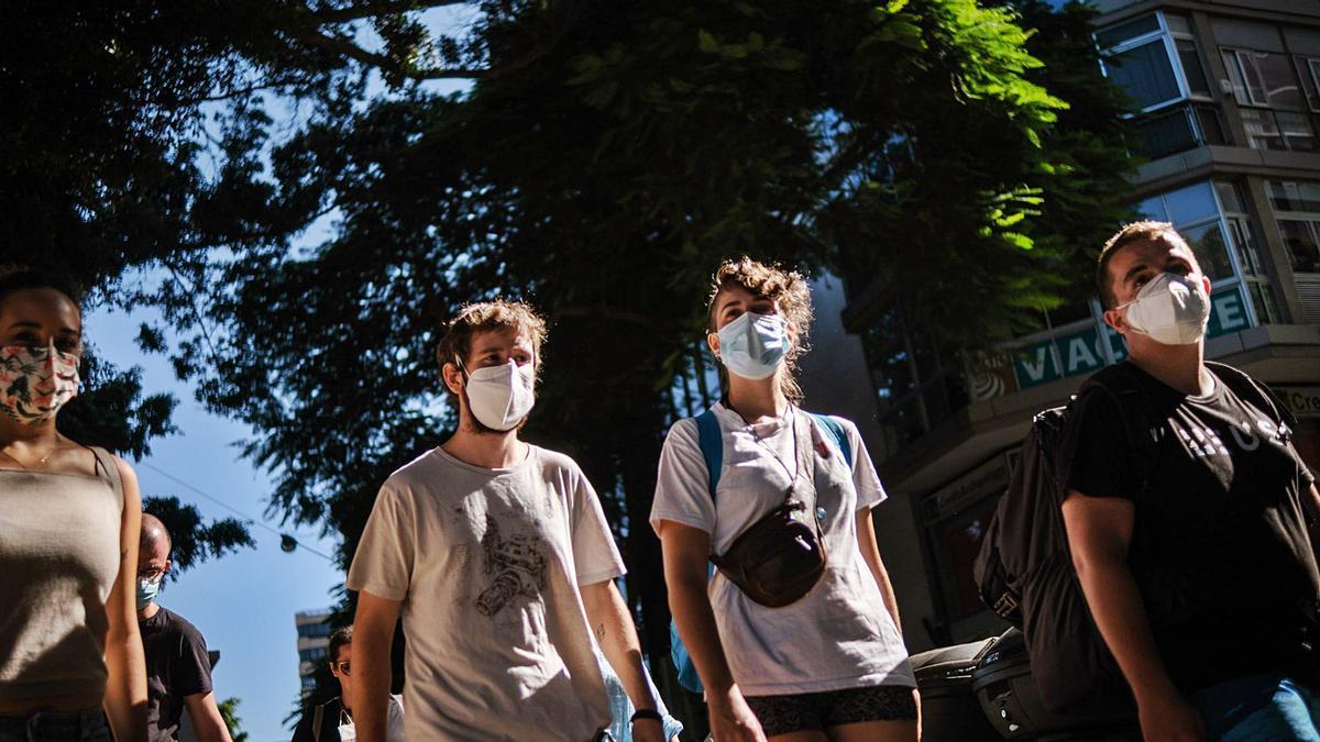 Un grupo de jóvenes camina con mascarilla por el centro de Santa Cruz de Tenerife.