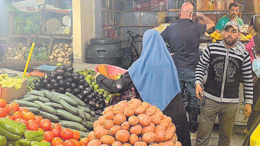 Saharauis y turistas realizan compras en un mercado local.