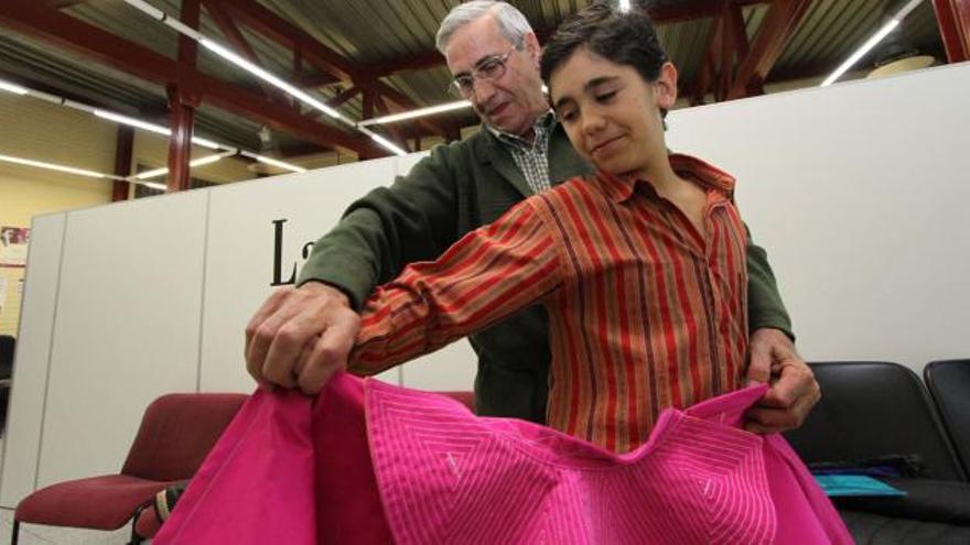 Víctor Prieto posa en la sede central del periódico con el dibujo premiado y con algunos de los regalos obtenidos.