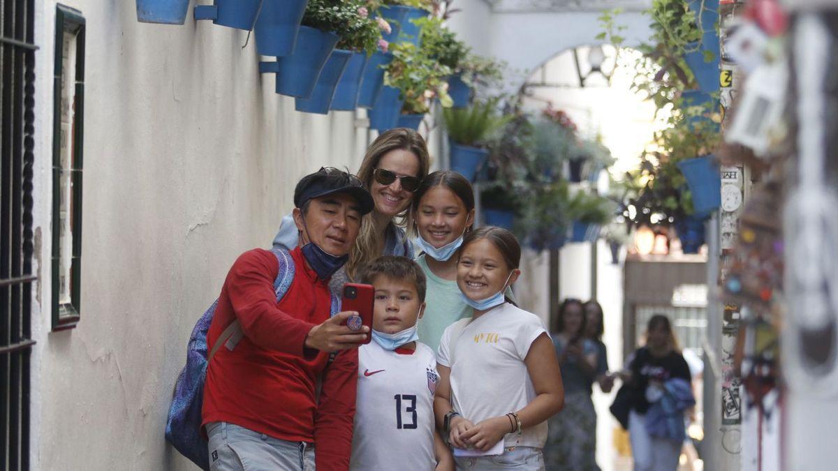 Una familia se toma una foto en la calleja de las Flores.