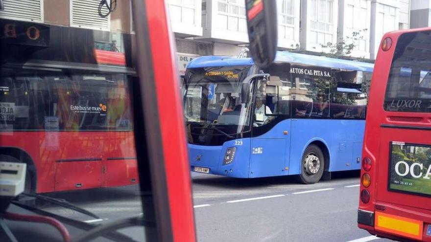 Buses urbanos y uno metropolitano, en la parada del cruce de la ronda de Outeiro con la avenida de Oza.