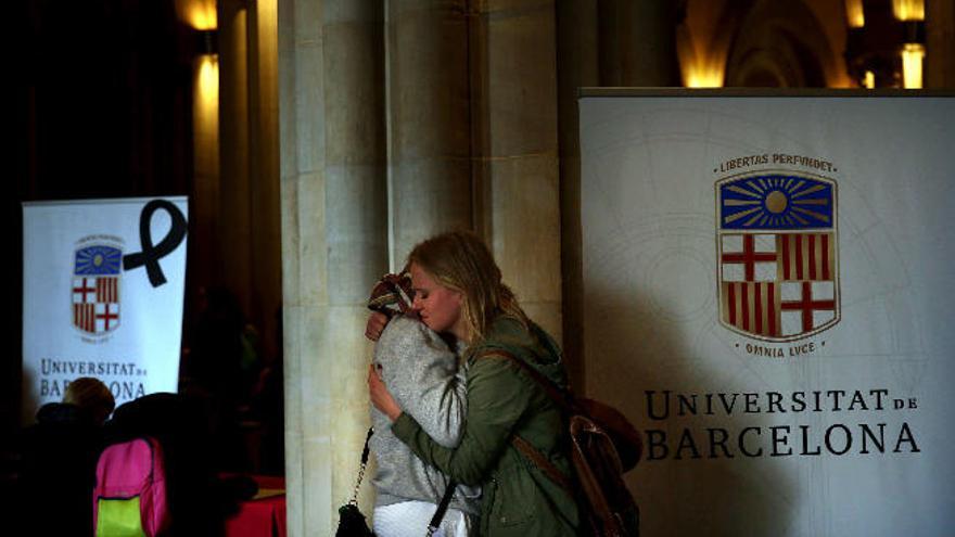Dos supervivientes se abrazan en la capilla ardiente de la Universidad de Barcelona.