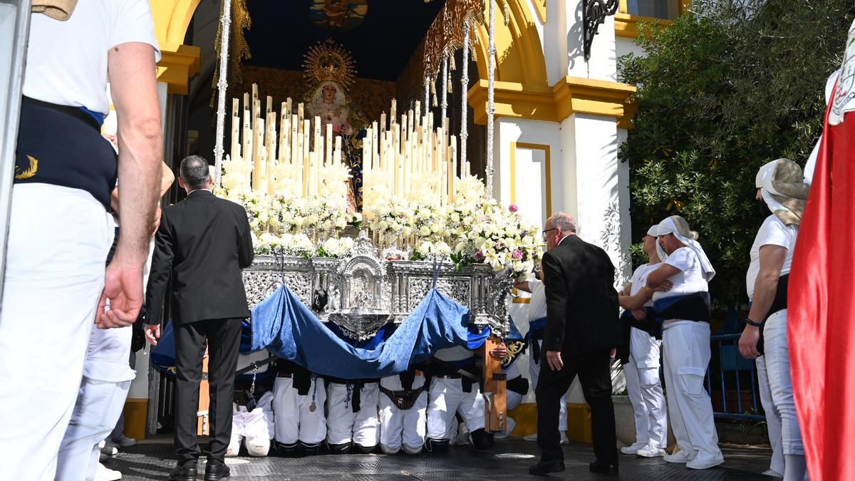 Los costaleros de rodillas en la salida de la Virgen de la Palma de la iglesia de San Roque.