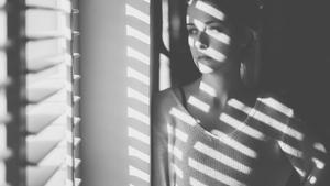 Mujer frente a la ventana en su casa