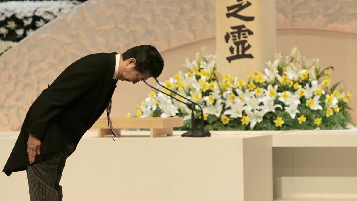 El primer ministro japonés Shinzo Abe hace una reverencia ante el Príncipe Akishino y la Princesa Kiko tras rezar ante el altar para honrar a las víctimas del tsunami.