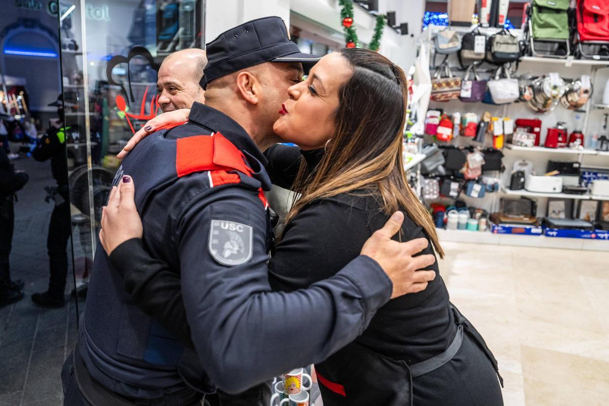 Uno de los agentes del grupo de proximidad de los Mossos d'Esquadra saluda a una tendera de Santa Coloma durante un patrullaje conjunto a la Policía Local