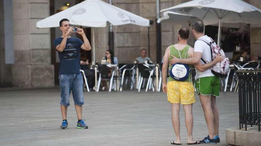 Dos turistas posan para una fotografía, en la plaza de María Pita.