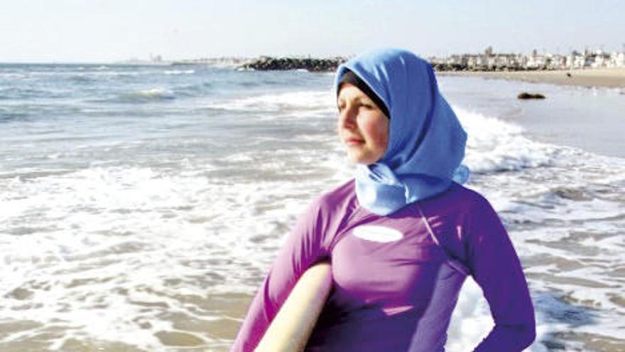 Una mujer con &quot;burkini&quot; y una tabla de surf en Cannes. // FdV