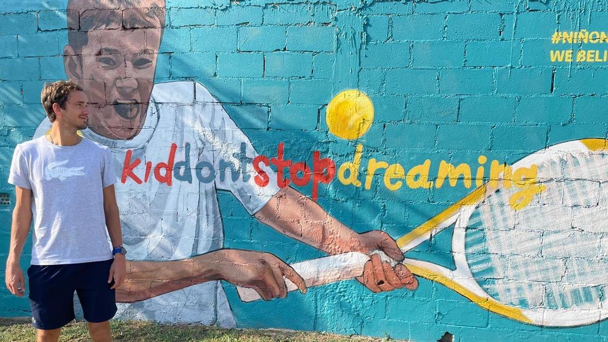 Daniil Medvedev con un grafiti en el que un niño golpea a la pelota con el lema: 'los niños no deberían dejar de soñar&quot;
