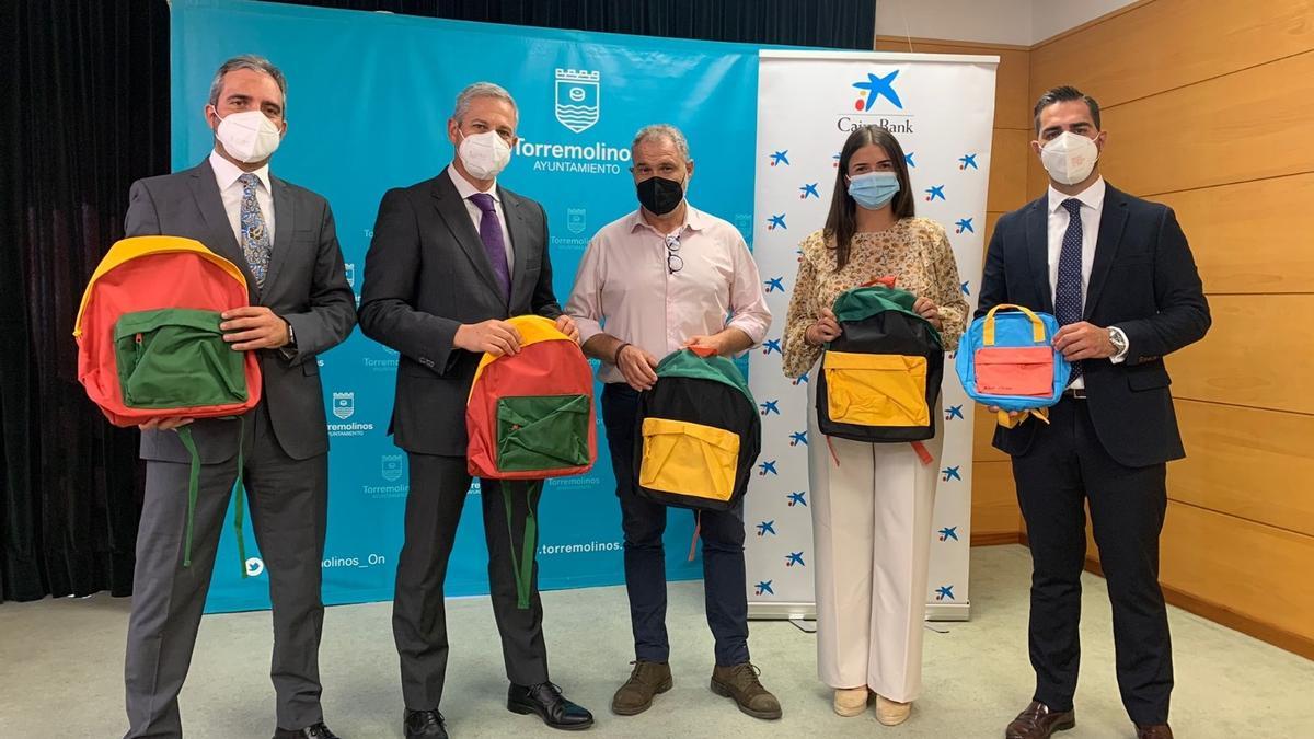 Los directivos de la Fundación la Caixa entregan las mochilas a los ediles César Carrasco y Lucía Cuín.