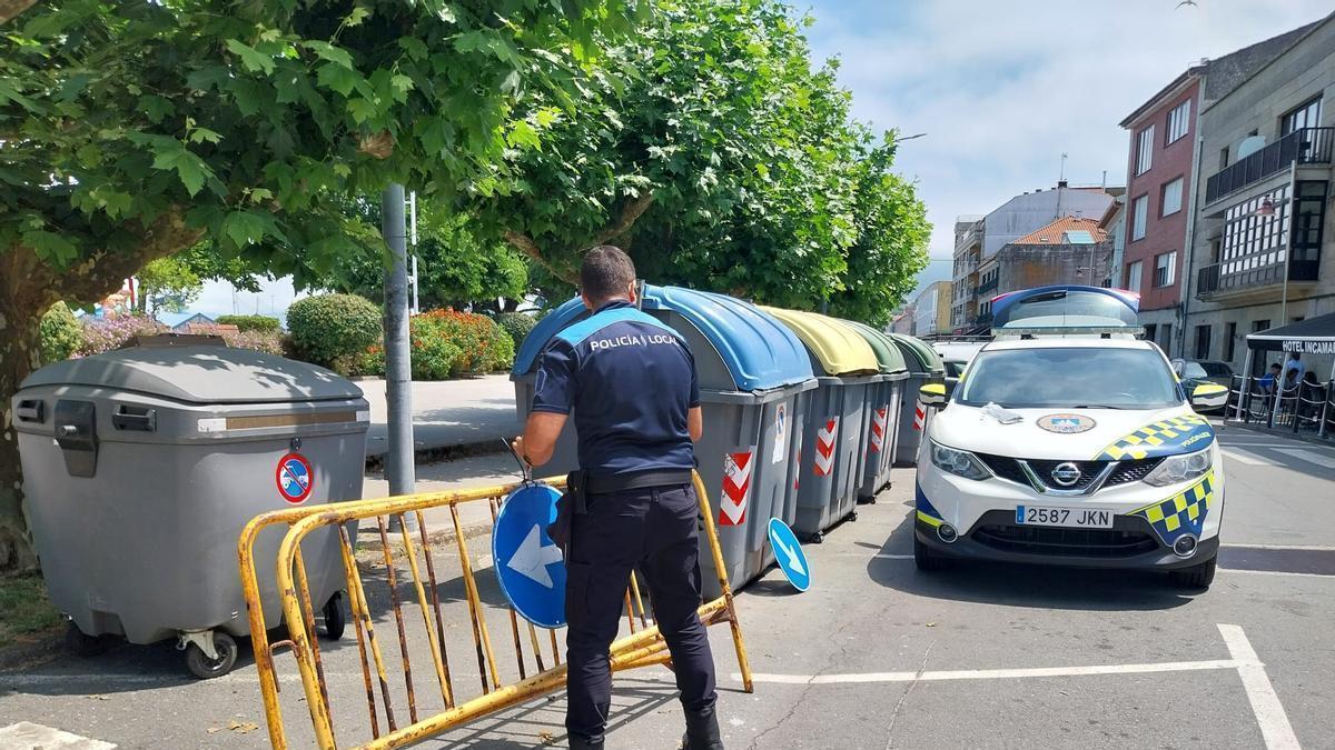 Un agente de la Policía Local de Bueu y el coche patrulla en el centro del municipio.