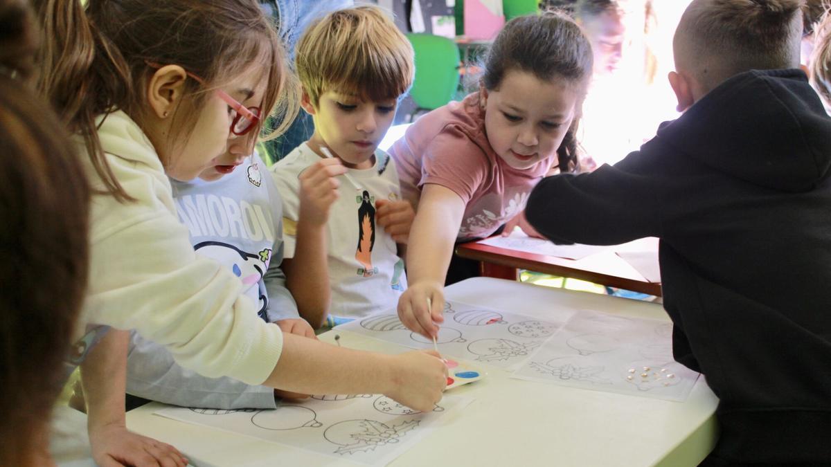 Varios niños pintan en el Campus de Navidad de Las Rehoyas.