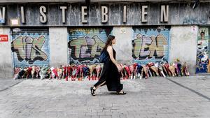 Una mujer pasa por la tienda de uniformes de trabajo ‘Vistebien’, donde el pasado lunes, 3 de julio, apuñalaron a Conchi, la dueña del establecimiento, en la Plaza de Tirso de Molina, a 5 de julio de 2023, en Madrid (España).