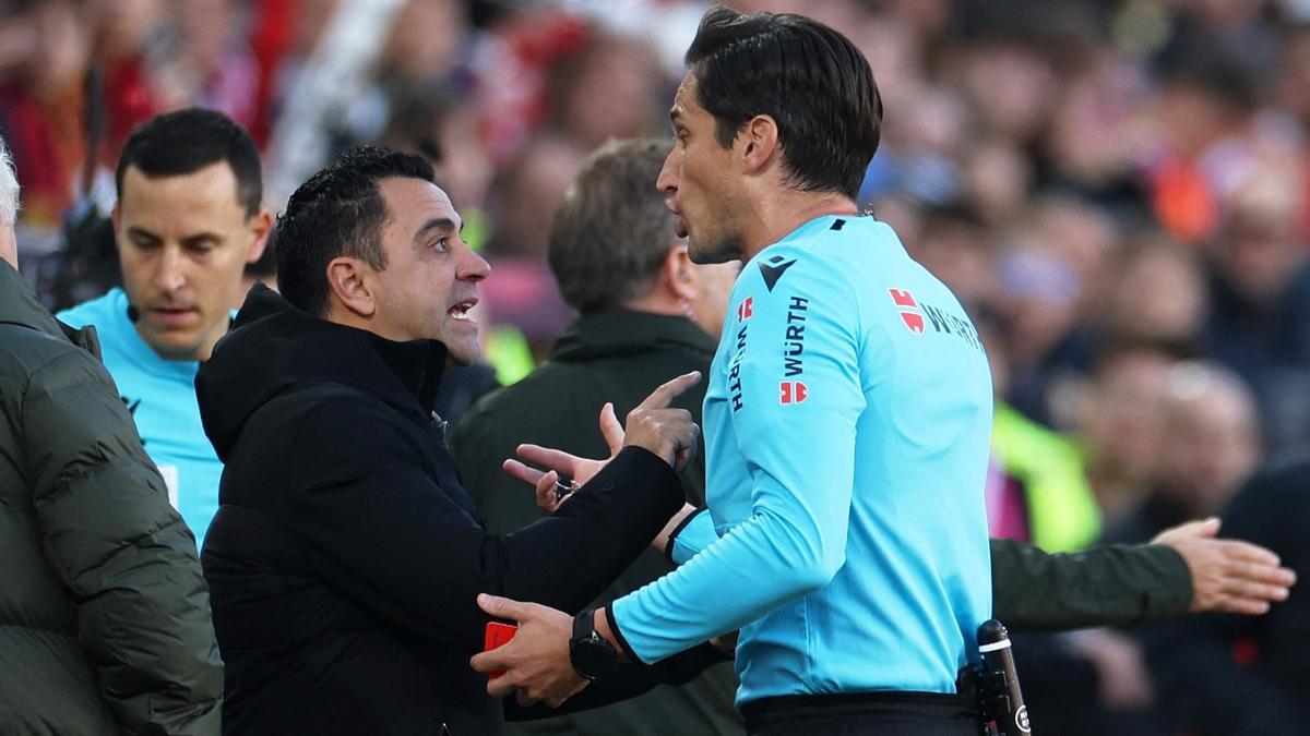 Xavi Hernández habla con el árbitro José Luis Munuera Montero en el tramo final del duelo de Vallecas.