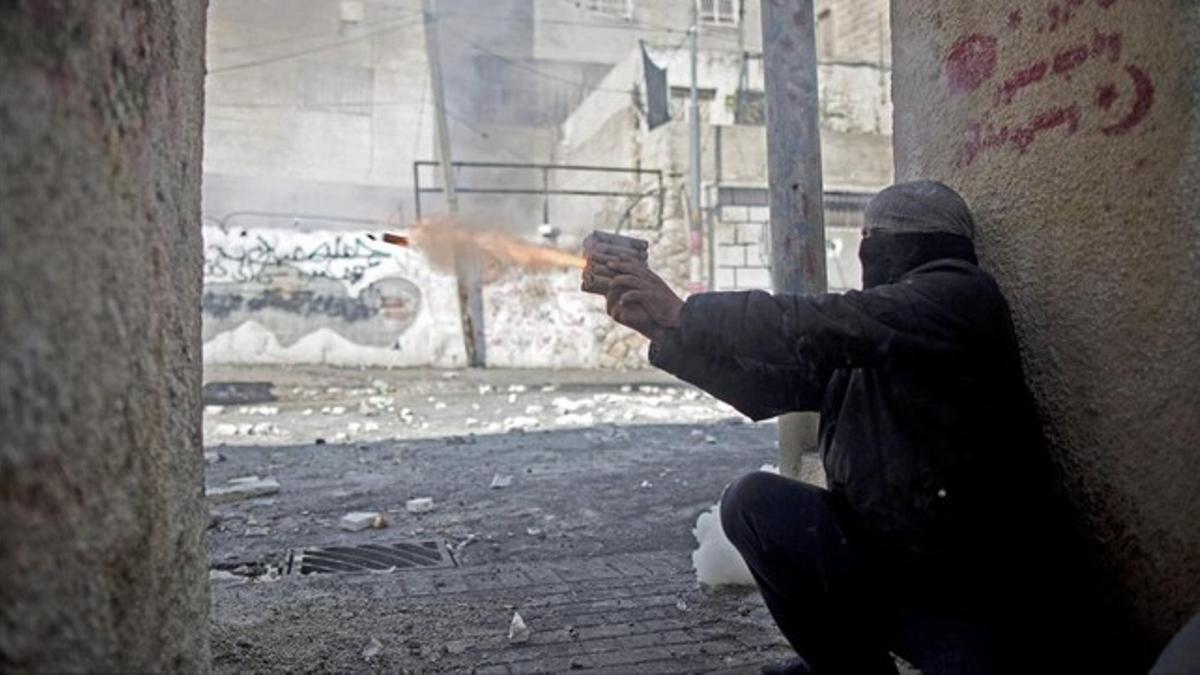 Un palestino lanza un petardo a las fuerzas de seguridad israelís.