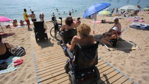 Bañistas con movilidad reducida en la playa del Petroli de Badalona