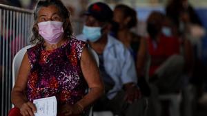 Una mujer espera su turno para recibir la segunda dosis de la vacuna Pfizer contra la covid-19 en la escuela republica de Colombia en San Miguelito (Panamá).
