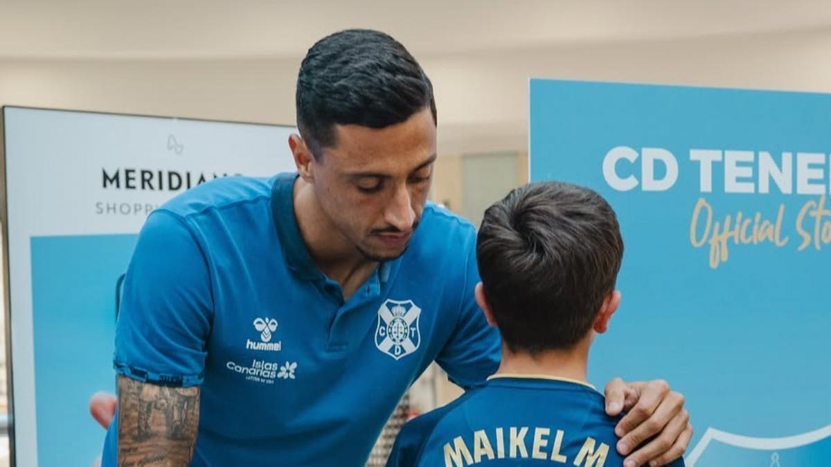 Maikel Mesa ajusta una camiseta a un niño.