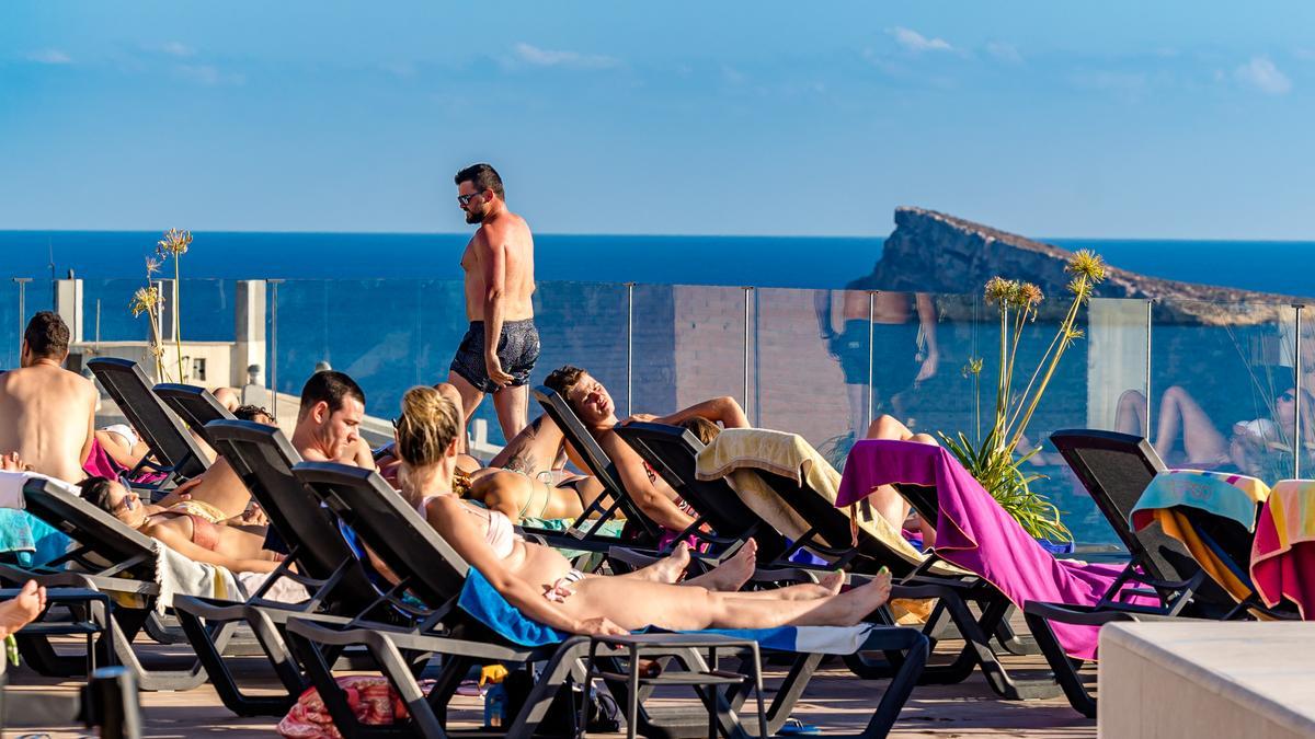 Un grupo de turistas toma el sol en la terraza de un hotel de Benidorm.