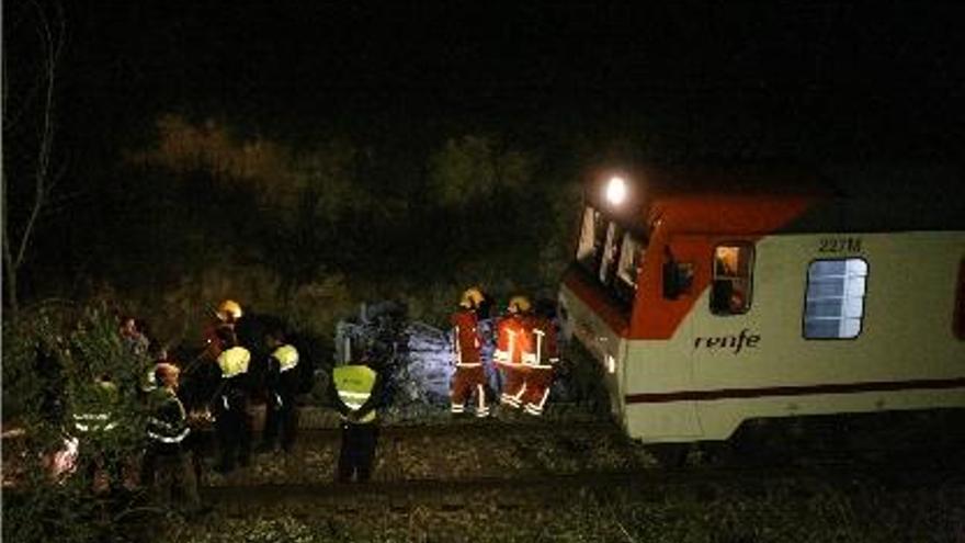 Miembros de los equipos de emergencias, minutos después de liberar el coche del tren.