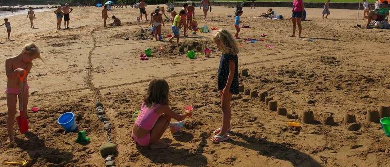 Los participantes, divididos en grupos, creando sus castillos de arena ayer en la playa de La Isla.