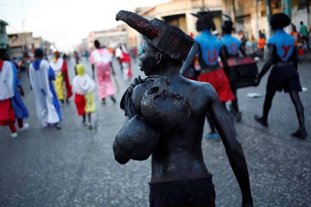 Un hombre desfila con dos calaveras humanas en la espalda en el carnaval de Puerto Príncipe, en Haití.