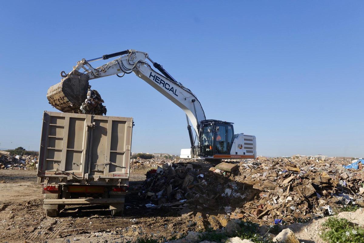 Una excavadora llena un camión con residuos, en el vertedero de Castellar.