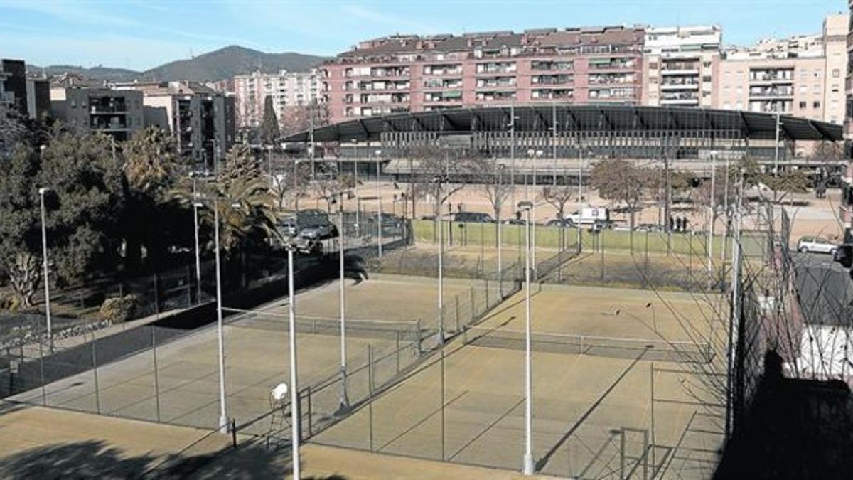 Pistas de tenis sobre las que está previsto levantar el pabellón deportivo, ayer. Al fondo, el edificio del Canódromo, en el que ya se trabaja para poder abrir en septiembre.