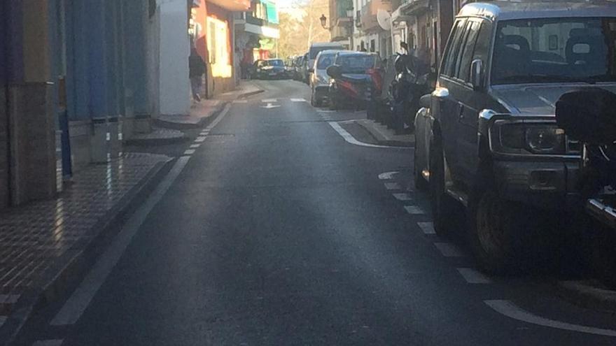 Una vecina transita por la acera de la calle Málaga.