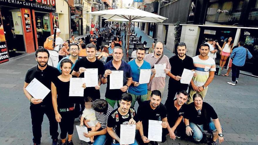 Hosteleros muestran el escrito remitido al alcalde, con los veladores de la calle Castaños detrás.