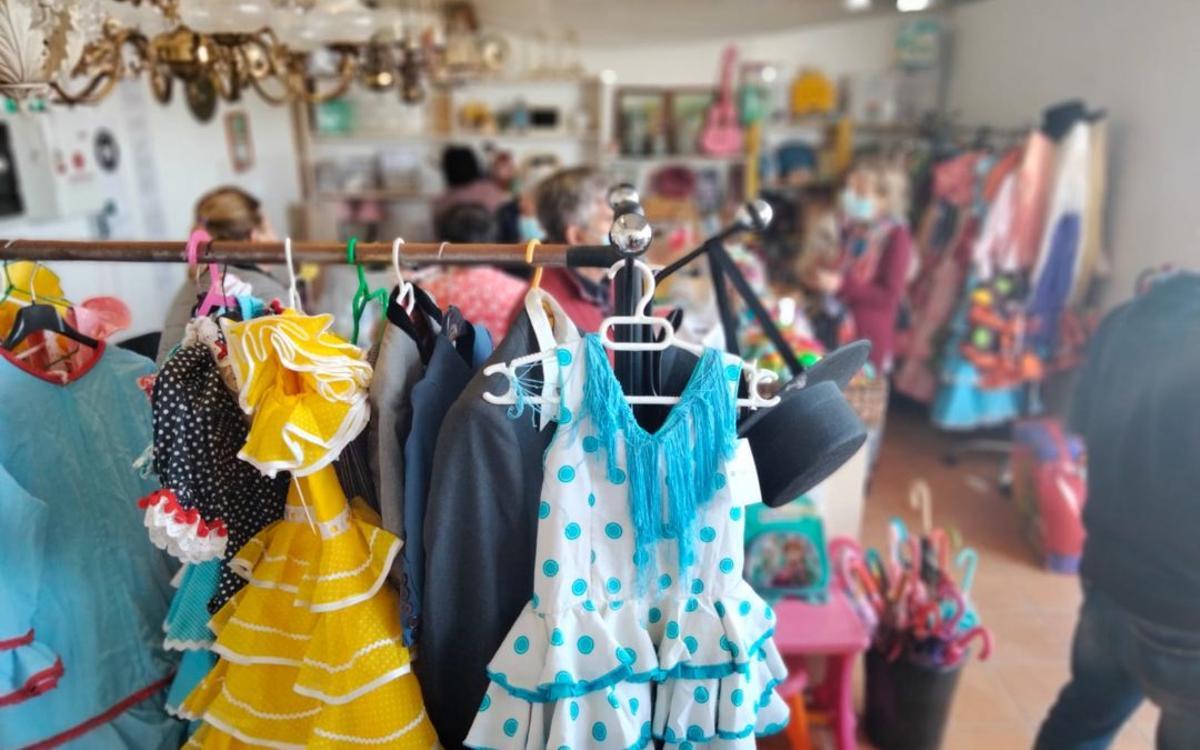Exposición de traes de flamenca infantiles en de las tiendas solidarias de Madre Coraje en Jerez