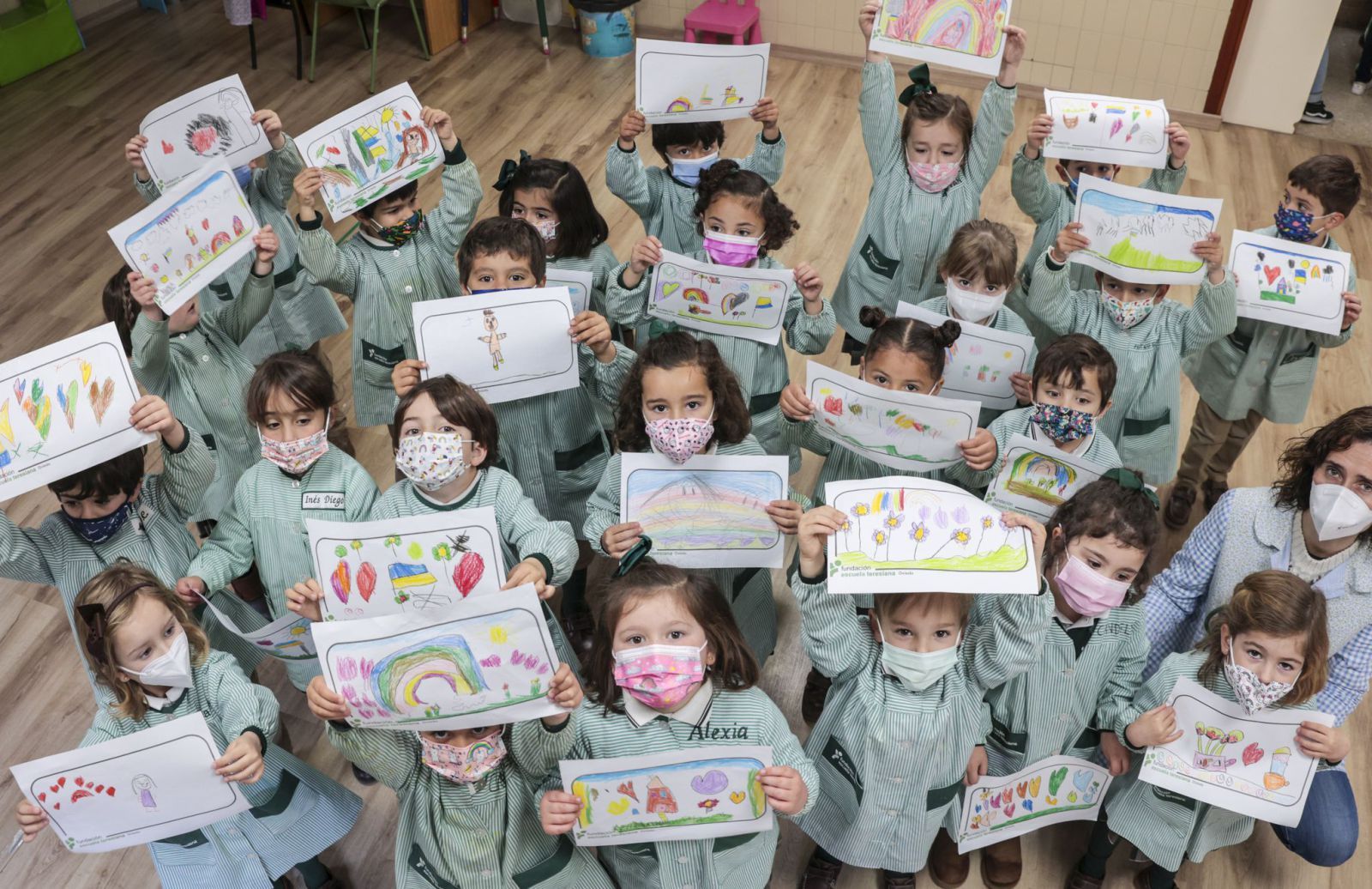 Los alumnos de segundo A de Infantil, junto a su profesora Covadonga Martínez, con los dibujos hechos ayer.  |  IRMA COLLÍN