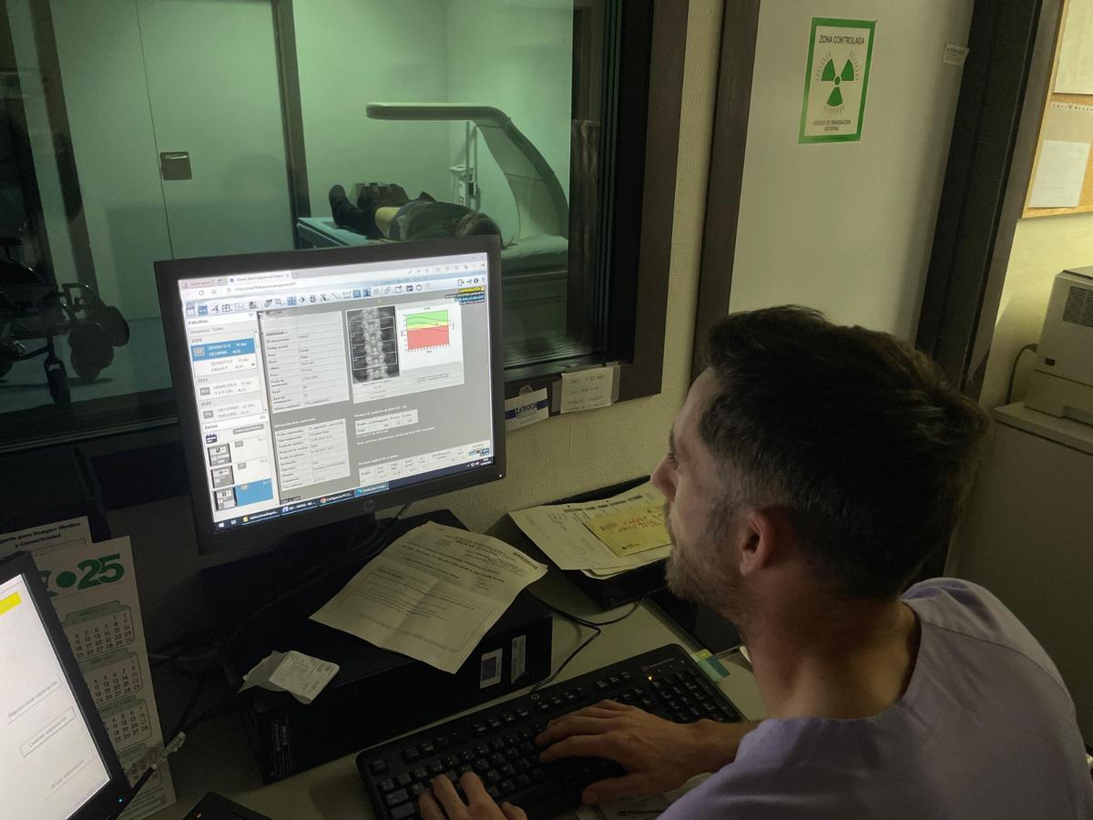 Un especialista observa los resultados de una prueba de densidad ósea en el ordenador