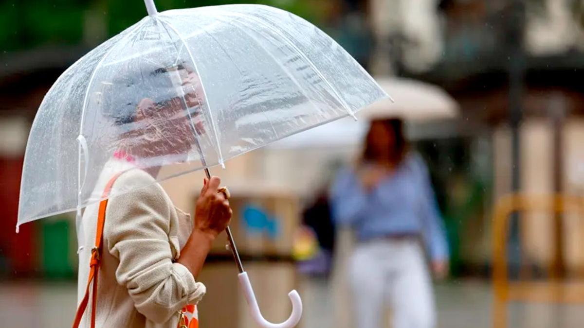 Una mujer se resguarda contra la lluvia.