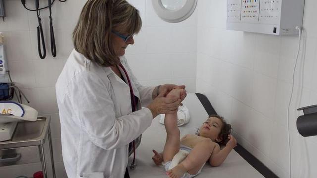 Una pediatra revisa a una niña en su consulta. | JOAN CORTADELLAS