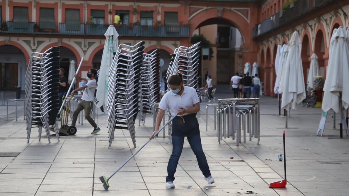 Los últimos clientes abandonan la plaza de la Corredera mientras se ultiman, hoy, las tareas de recogida.