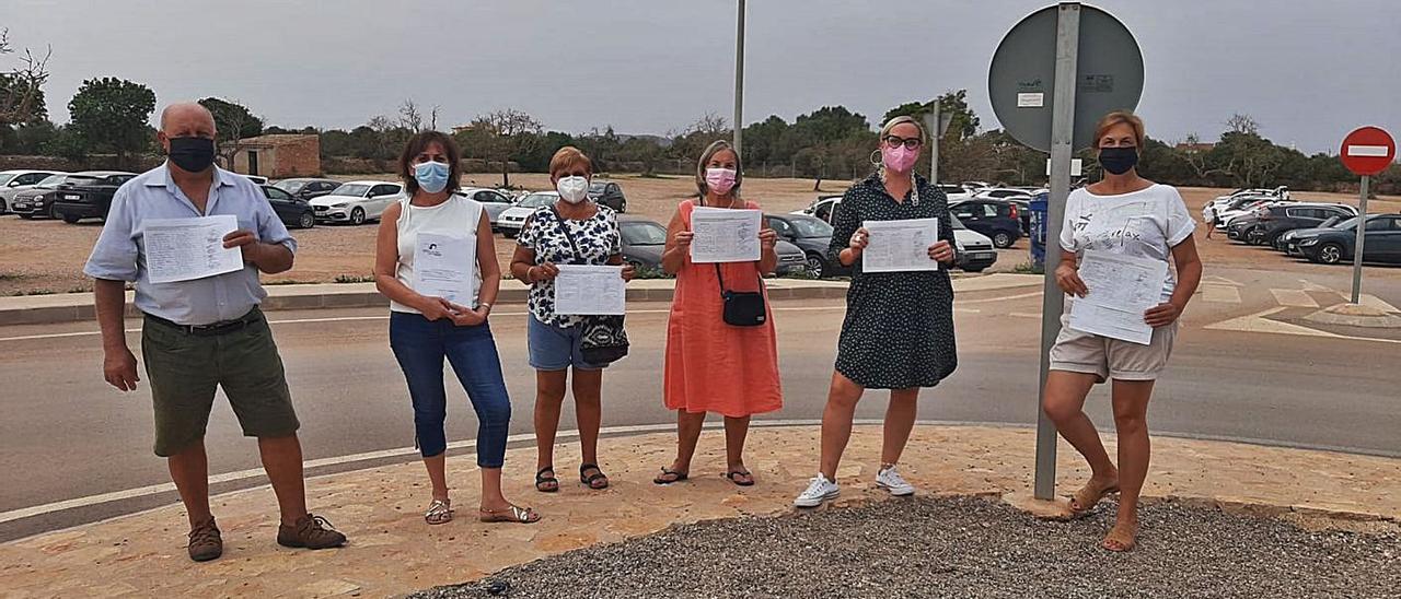 Miembros de la asociación de vecinos de Cala Llombards, con las firmas en el parking. | A.V.C.LL.