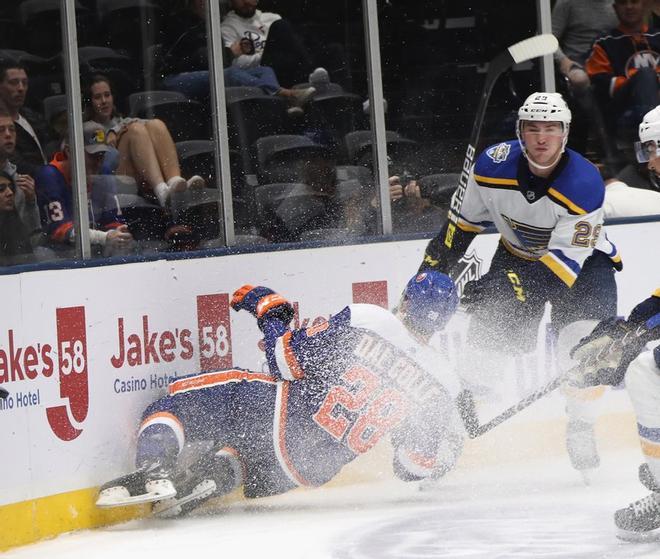 Michael Dal Colle # 28 de los New York Islanders es golpeado por Vince Dunn # 29 de St. Louis Blues durante el segundo período en el Coliseo Nassau de NYCB Live.