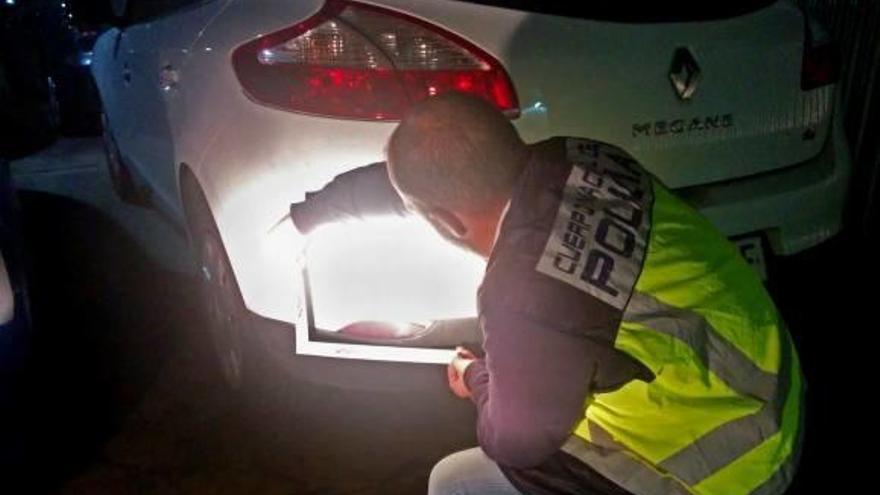 Un agente inspecciona uno de los vehículos investigados.