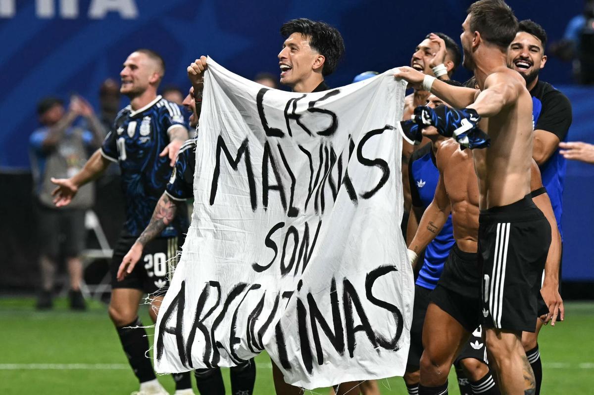Argentina's players hold a banner reading "The Malvinas (Falkland Islands) belong to Argentina," after winning the 2026 World Cup football tournament semi-final match between England and Argentina at the Atlanta Stadium in Atlanta on July 15, 2026. (Photo by Paul ELLIS / AFP)