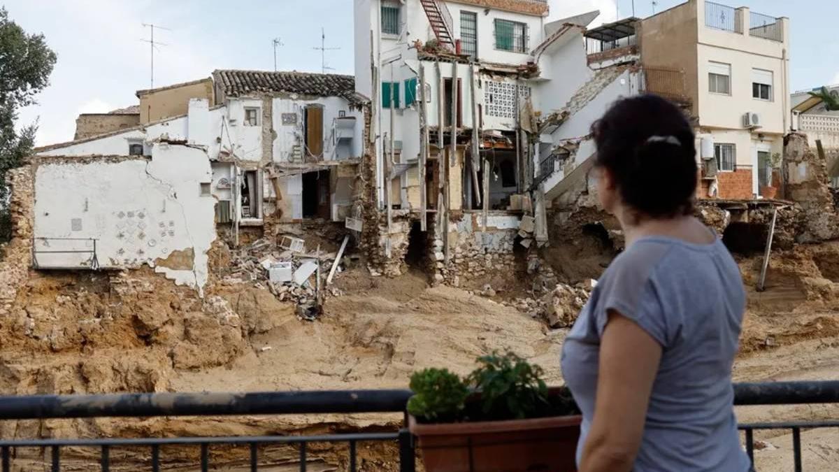 Una mujer observa varias casas dañadas en Chiva (Valencia) tras la dana.