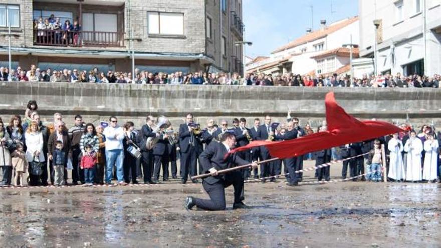 César Menéndez realiza el tradicional movimiento de bandera en la playa de La Ribera.