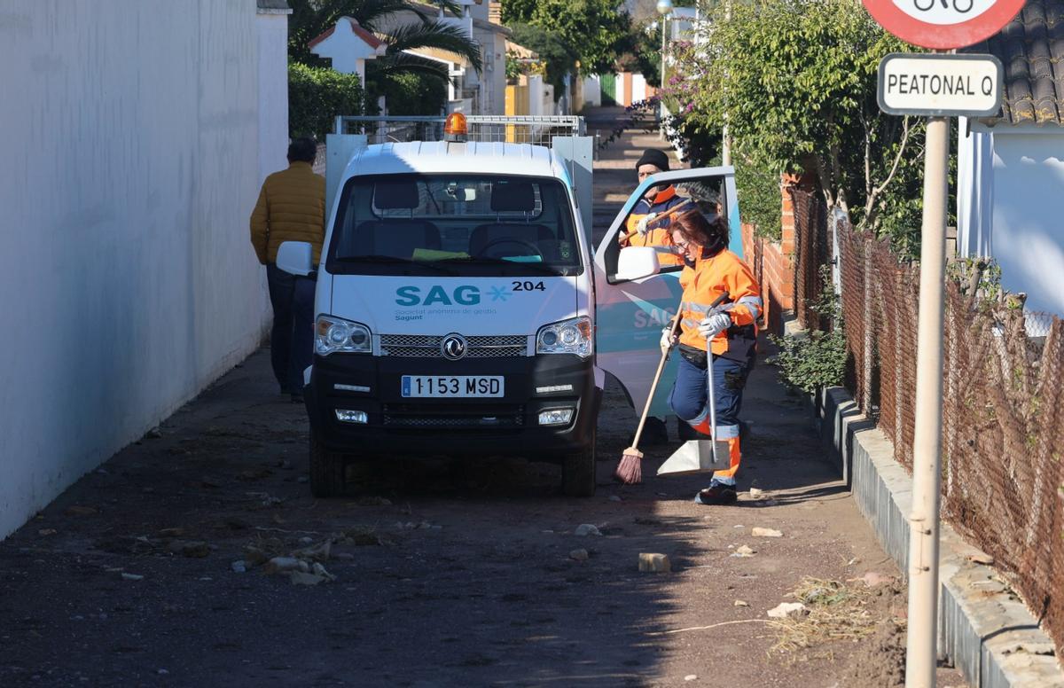 Operarios de la empresa municipal, limpiando calles en la Malvarrosa.