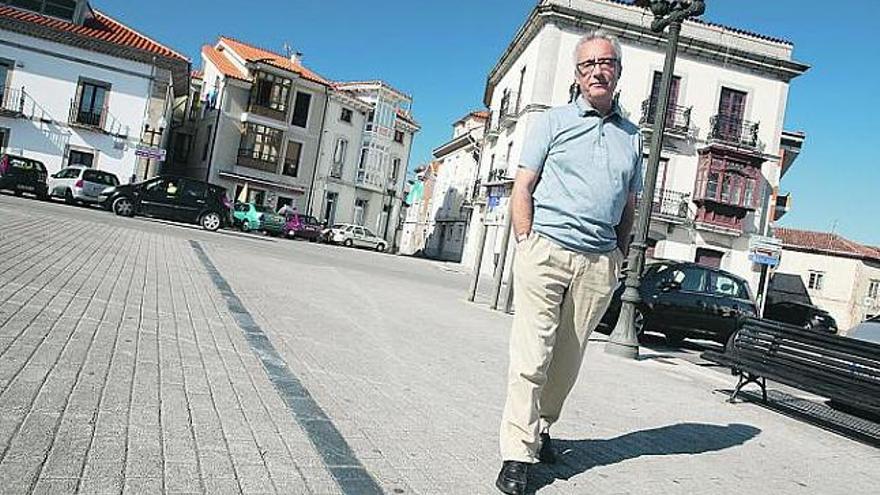 Juan José Millás y su sombra, en la plaza del Marqués de Muros de Nalón.