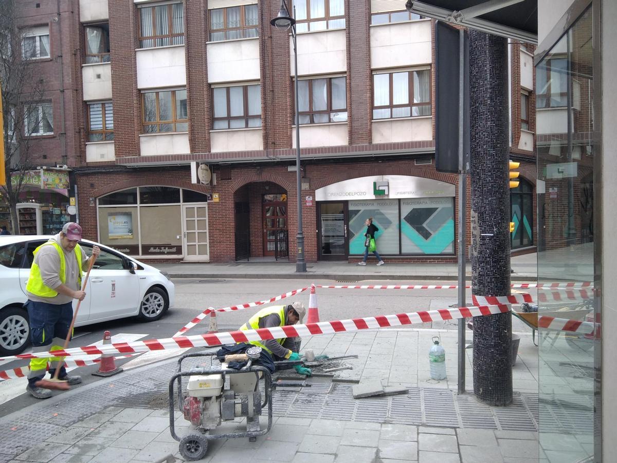 Operarios trabajando este lunes en un tramo de acera de la avenida Schultz.