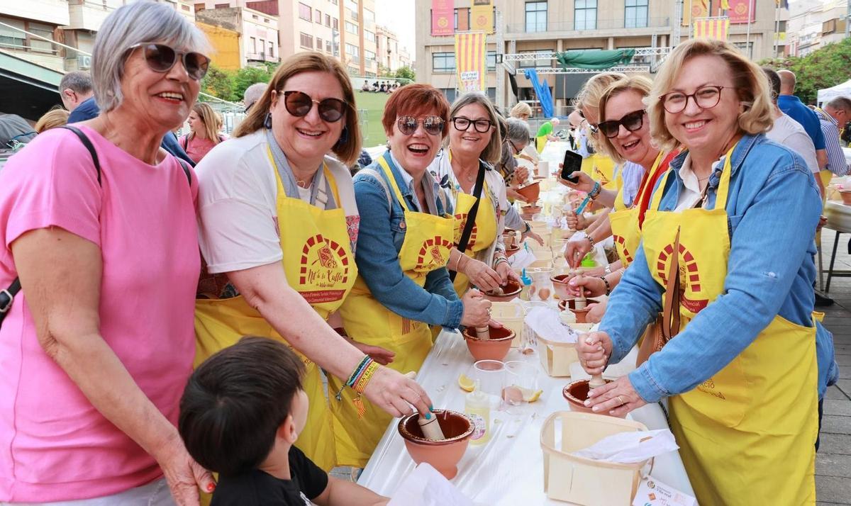 Unas vecinas de Vila-real compiten en las últimas fiestas patronales por asegurarse una buena posición en el encuentro para hacer 'allioli' previo a la Xulla.
