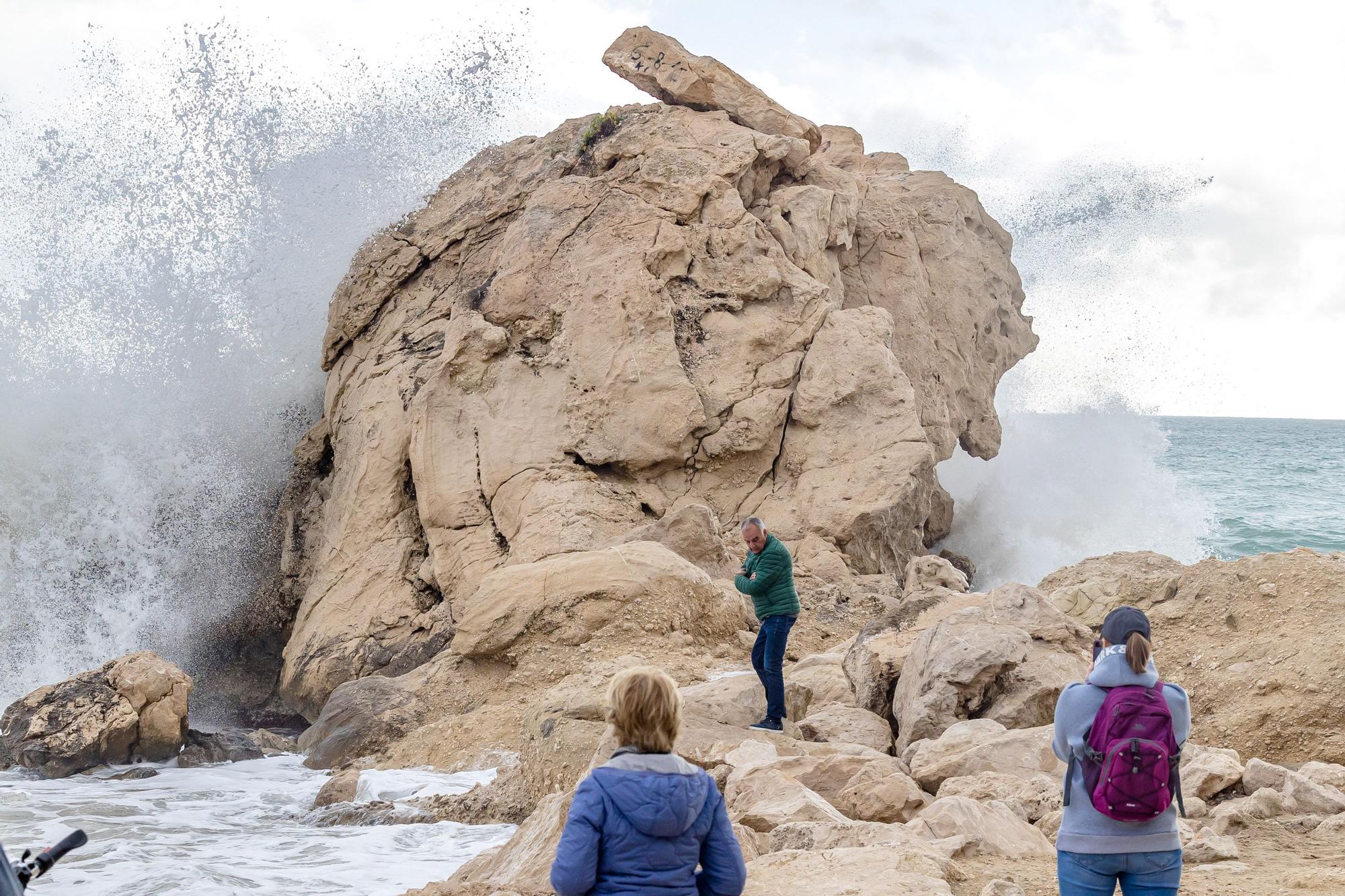 Turistas y paseantes observan el temporal de mar en la Cala de Finestrat